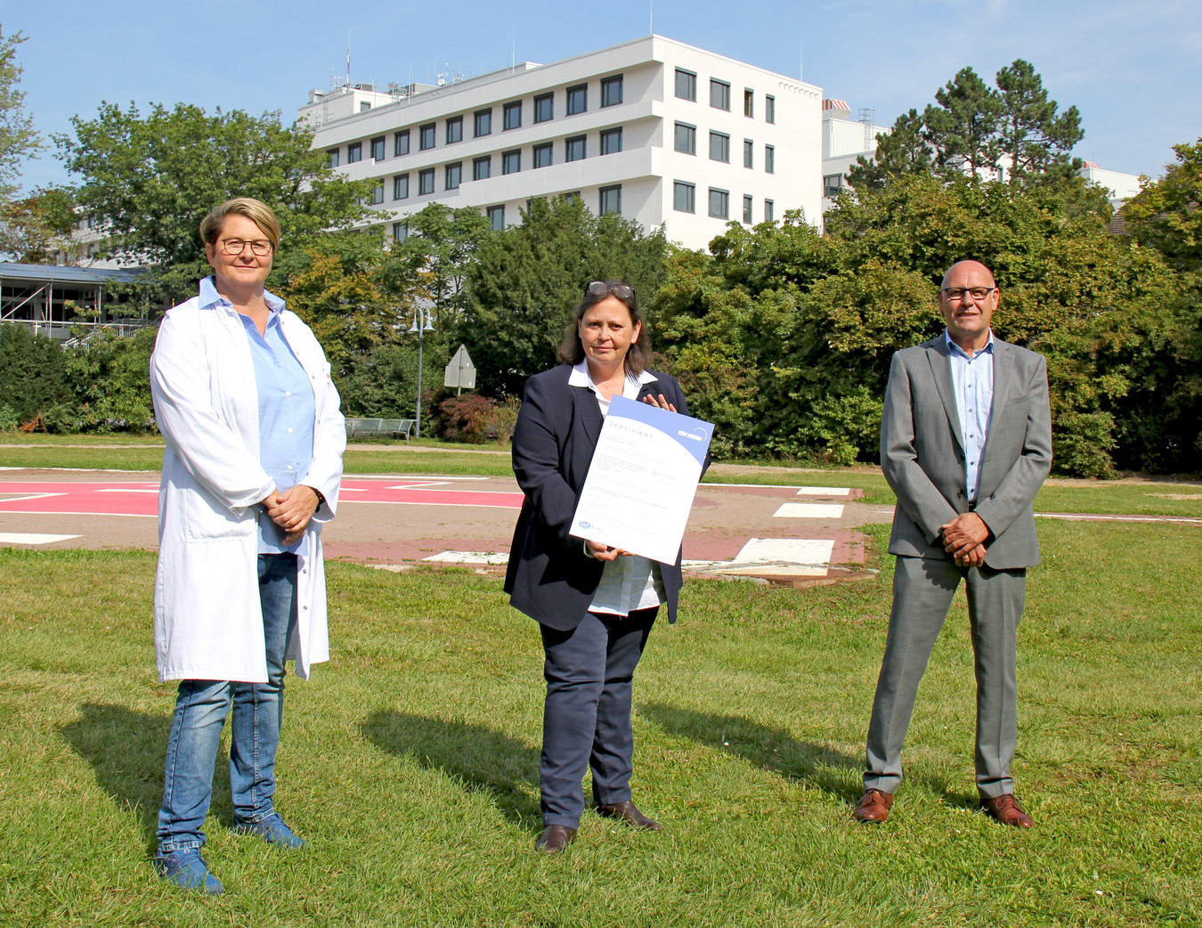 Chefärztin Prof. Dr. med. Sibylle C. Roll (Bildmitte) präsentiert gemeinsam mit Oberärztin Dr. med. Silke Lubik und Uwe Tegtmeier vom Qualitätsmanagement die Urkunde vom Qualitätssiegel des TÜV Nord Cert.