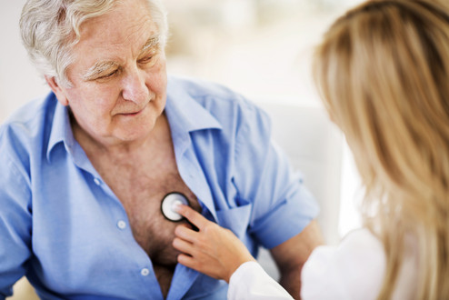 Ärztin untersucht älteren Patienten