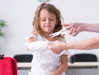 Mädchen bekommt Verband angelegt