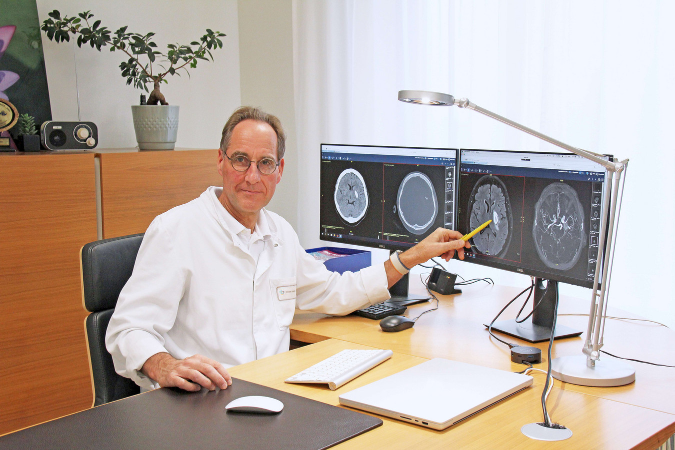 Schlaganfallexperte Prof. Dr. med. Thorsten Steiner, Chefarzt der Neurologie am varisano Klinikum Frankfurt Höchst, vor Monitoren mit Aufnahmen von Hirnblutungen.