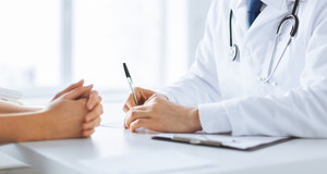 Close Up Arzt-Patientin-Gespräch sitzend an einem weißen Tisch