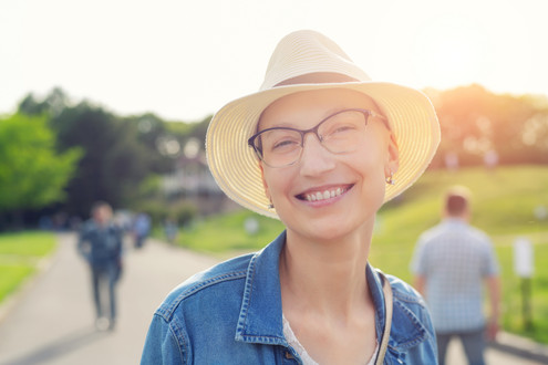 Frau mit Sonnenhut lächelt 