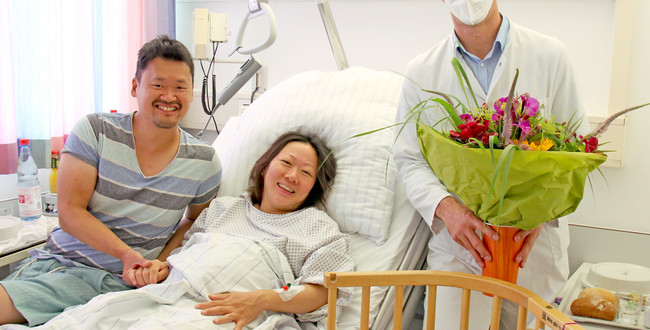 Der Chefarzt der Klinik für Gynäkologie und Geburtshilfe, Prof. Dr. med. Joachim Rom, überreicht den glücklichen Eltern der 1111 Geburt am varisano Klinikum Frankfurt Höchst einen Blumenstrauss.