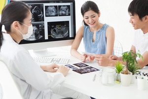 Eine Ärztin berät ein junges Paar zur Schwangerschaft