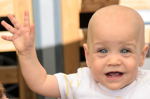 Baby winkt und lächelt